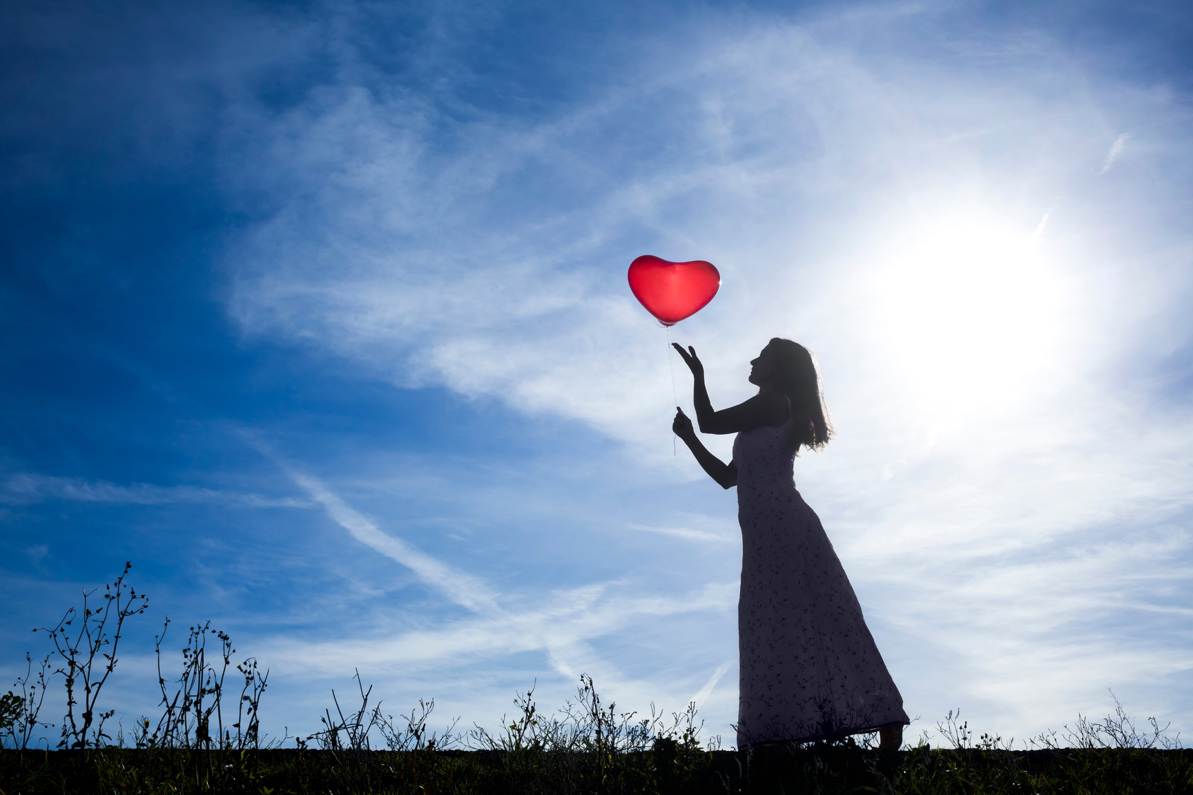 silhouette of woman with heart ballon